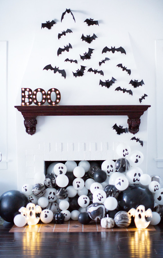 Chimenea decorada para Halloween con murciélagos y globos blancos y negros