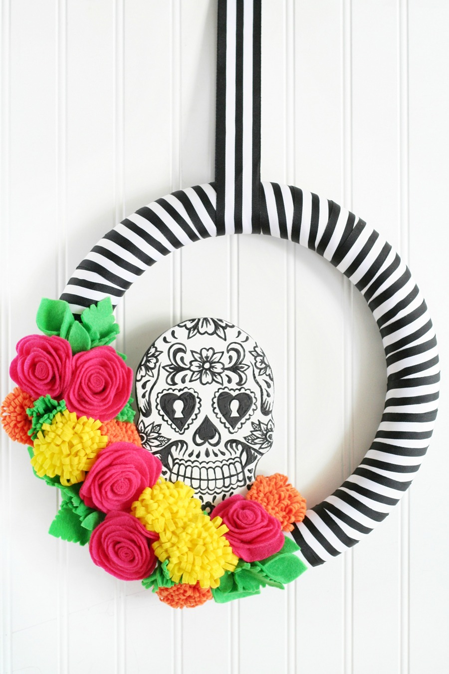 Corona de día de muertos, con calavera y flores de colores